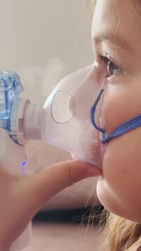 6 years old girl with nebuliser breathing medications. Close-up treatment of Adenoiditis, asthma, cough 