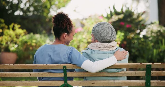 Back, bench and elderly woman with caregiver outdoor in retirement community with daily assistance and support. Senior person, nurse and relax with conversation and wellness by residential care home.