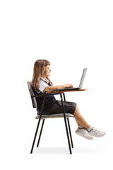 Schoolgirl sitting in a school chair with a laptop computer