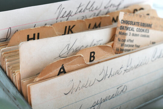 Vintage handwritten recipes on cards filed in a recipebox box