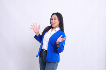 The charm of a beautiful young Asian office woman wearing a blue formal suit is standing obliquely to the right, cheerful, both hands open. for corporate, beauty, business, financial content