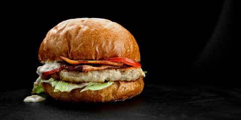 Burger with chicken cutlet, bacon and tomatoes