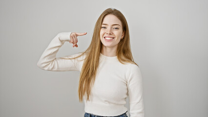 Smiling young caucasian woman pointing at her face on a white background