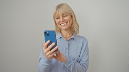 Fototapeta premium Smiling woman using smartphone against white background