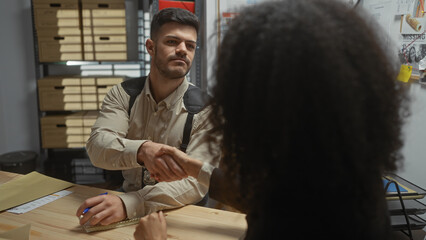 A man and woman, detectives in an office, shaking hands over a case file, with evidence board in background.