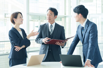 オフィスで立ち話をするビジネスパーソン