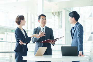 オフィスで立ち話をするビジネスパーソン