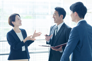 オフィスで立ち話をするビジネスパーソン