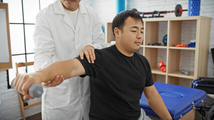 Obraz premium A male physiotherapist guides a patient through rehabilitation exercises in a well-equipped, modern clinic.