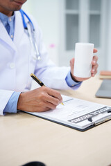 A medical doctor is working at a desk, analyzing patient data related to heart attacks and...