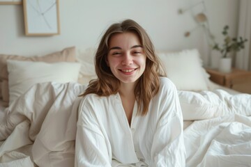 Smiling Woman in White Robe, Sitting on Bed in Cozy Room