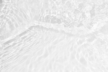 Obraz premium White water with ripples on the surface. Defocus blurred transparent white colored clear calm water surface texture with splashes and bubbles. Water waves with shining pattern texture background.