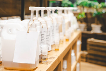 Blank tag with pump dispensers in a row. Side shot of refillable cleaning product like shampoo and soap in dispenser tank for sustainable and eco friendly lifestyle. zero waste store. Copy Space.