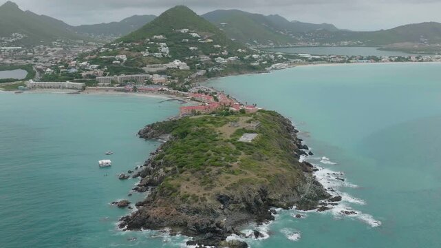 Aerial shot of Fort Amsterdam Sint Marteen on island during daytime with beautiful hills at background. Pan view.