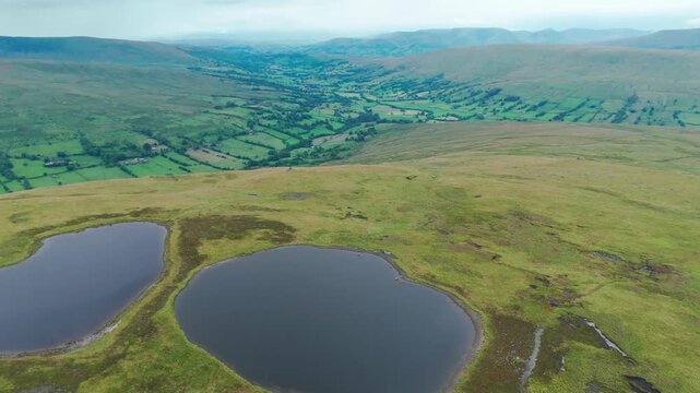 Forward moving drone shot reveling beautiful landscape behind Whernside tarns in England.