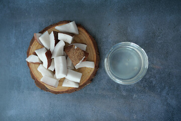 slice of fresh coconut and bottle of oil on a table 