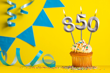Lighted birthday candle number 850 - Yellow background with blue pennants