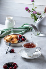 Cheesecakes with berries and tea in a cup