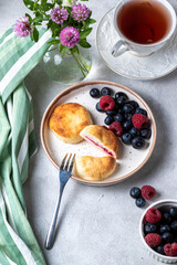 Cheesecakes with berries and tea in a cup
