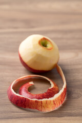 Peeled red apple fruit (Envy apple) on wooden background