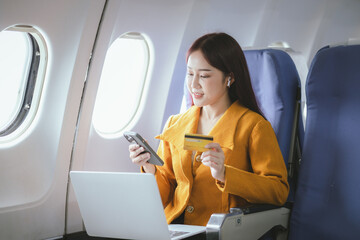 A confident businesswoman sits in first class on a commercial flight, using her laptop to stay connected online. Elegantly dressed, she enjoys a comfortable journey, balancing work and relaxation with