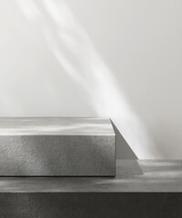 Gray and black geometric shape natural rock stone platform in dappled sunlight on white wall for...