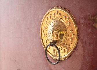 The golden doorknob on the gate