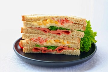 Homemade ham with sweet corn  sandwich in black plate on white background