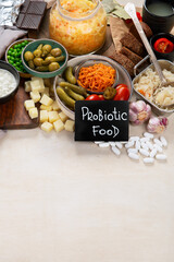 Probiotic food concept. Cabbage in jar, pickle, carrot on light wooden background