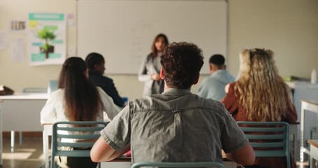 Classroom, students and raised hand for teacher question with education, learning and knowledge in academy. High school, people and pupil back with asking for solution, scholarship and why for answer - Powered by Adobe