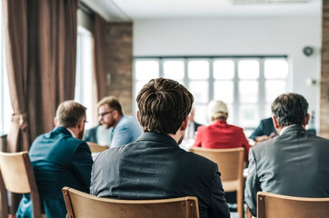 Back view of business people attending a conference