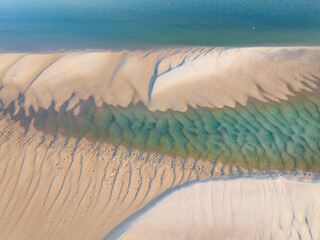 Aerial view of water pools and patterns in sandbars at low tide