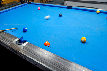 playing nine ball billiards on a blue billiard table