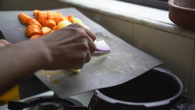 A South Asian man cooking vegetables