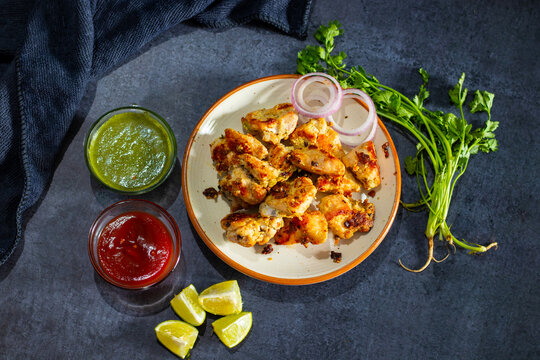 Chicken reshmi kabab or chicken malai kabab, delicious Mughlai cuisine, serve with mint chutney and tomato sauce. selective focus. 