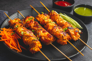 Deliciously Spiced Chicken Tikka Kabab, A Flavourful Grilled Delight with Tangy Marinade and Smoky Charcoal Aroma Serve with Mint and Tomato Chutney. Selective focus. 