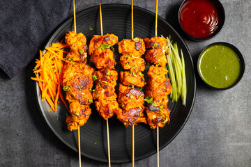 Deliciously Spiced Chicken Tikka Kabab, A Flavourful Grilled Delight with Tangy Marinade and Smoky Charcoal Aroma Serve with Mint and Tomato Chutney. Selective focus. 