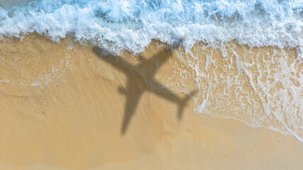Aerial view of shadow passenger plane silhouette and sandy beach  blue sea with waves at sea beach summer vacation sea travel concept