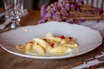 Postre exquisito con peras, bayas y salsa en un plato blanco.