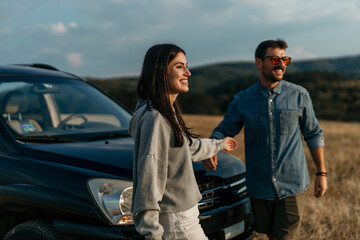 Loving urban styled couple getting out of the car, ready to enjoy sunset in nature