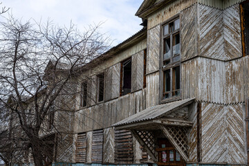 Boarded up windows. An old abandoned wooden house with boarded up windows and a crumbling roof