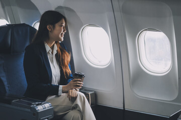 Asian woman sitting in a seat in airplane and looking out the window going on a trip vacation travel concept.Capture the allure of wanderlust with this stunning image