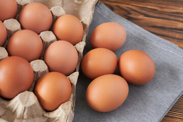 Eggs in a carton on a wooden table. Top view