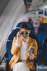 A young Asian woman, seated as an airplane passenger, contemplates dollar bills, reflecting on lucrative opportunities and aspirations towards billionaire status.