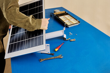 Installation of an autonomous, wireless solar street lamp, attaching solar panel to holder bracket