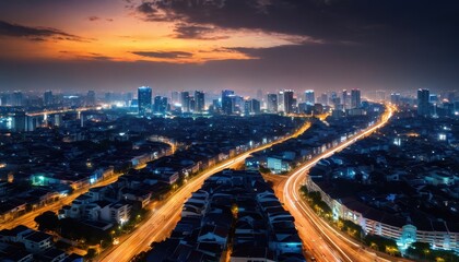 Night cityscape with highway and skyscrapers.