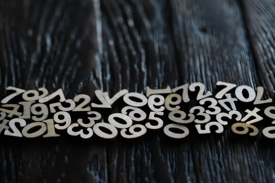 Wooden Numbers on Dark Wood Surface - Rustic and Educational Elements for Learning and Crafts