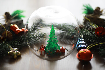 Festive Christmas Decorations with Miniature Tree in Glass Dome on Wooden Table