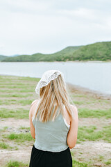 Back view of chilling young Asian female looking a amazing beautiful green mountain and lake view. Adventure travel and vacation concept.
