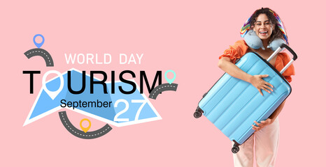 Young African-American woman hugging suitcase on pink background